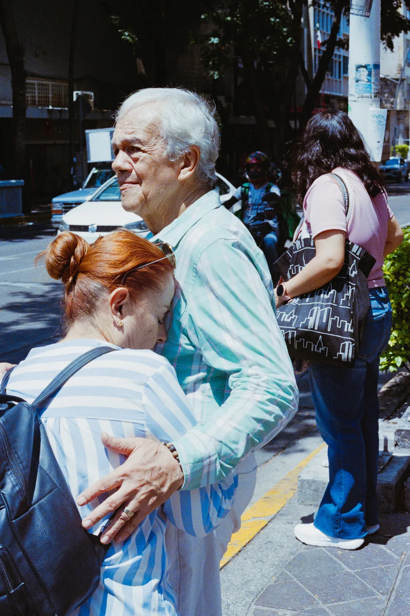 Pareja de adultos mayores abrazados esperando en una esquina
